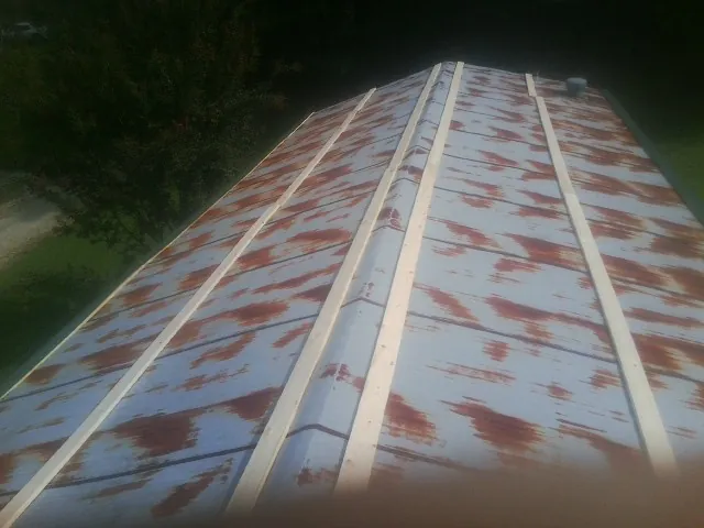 Rusted metal roof panels with new wood purlins before replacement — Storm Damage Roof Repair in Malcolm by Roofing Brothers
