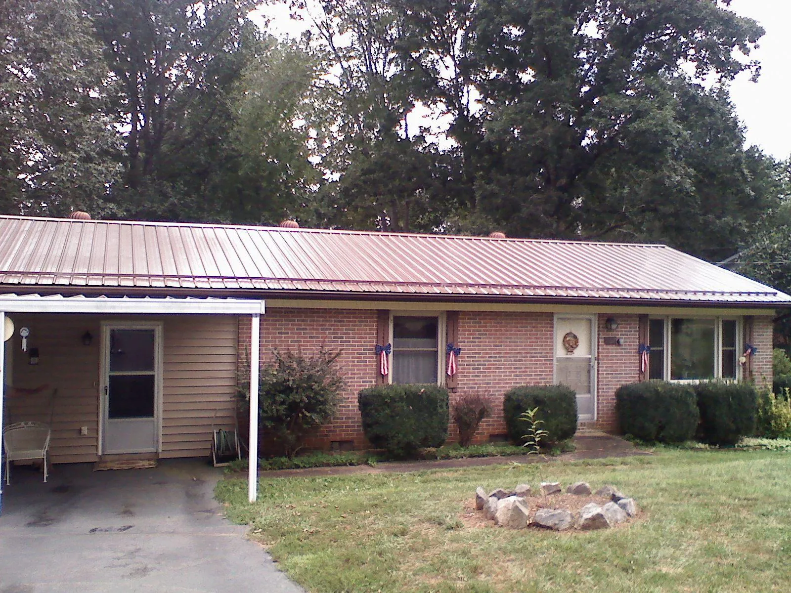 Bronze metal roof and carport on a brick ranch home — Roof Repair work by our crew in Malcolm